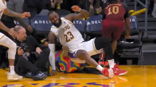 太危险了詹姆斯追防大帽对手上篮,落地摔倒撞翻摄影师表情痛苦